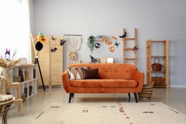 Cadılar Bayramı için kırmızı kanepeyle dekore edilmiş oturma odasının içi.