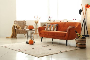 Cadılar Bayramı için kırmızı kanepe ve balkabaklarıyla dekore edilmiş oturma odasının içi.