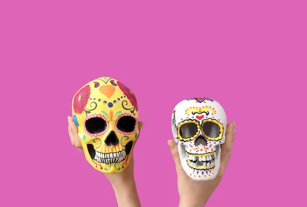 墨西哥死难者节 Dia Muertos 女性手拿着漆过的骷髅 背景为粉色 — 图库照片