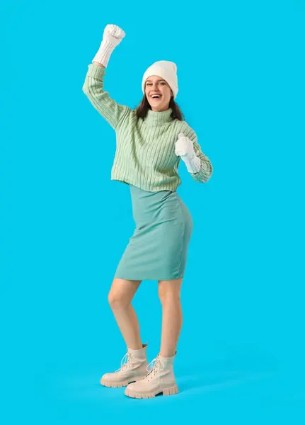 青の背景に冬服で幸せな若い女 — ストック写真