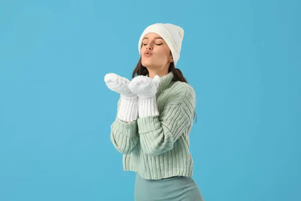 Νεαρή Γυναίκα Χειμωνιάτικα Ρούχα Φυσάει Φιλί Μπλε Φόντο — Φωτογραφία Αρχείου