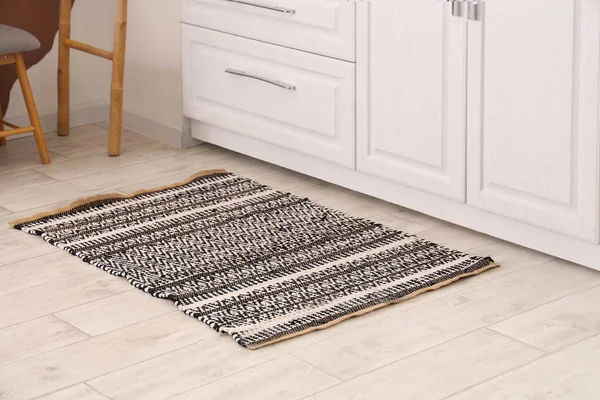 Stylish carpet on floor in light kitchen