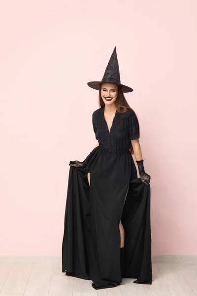 Νεαρή Γυναίκα Ντυμένη Για Halloween Μάγισσα Κοντά Στο Φως Τοίχο — Φωτογραφία Αρχείου