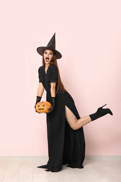 Шокированная Молодая Женщина Одетая Хэллоуин Ведьма Тыквой Светлой Стены — стоковое фото