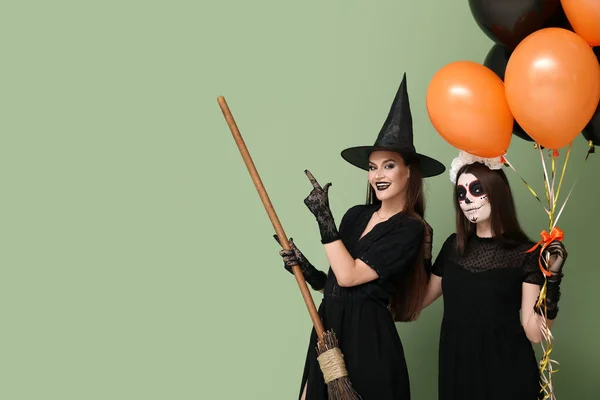 Jonge Vrouwen Gekleed Voor Halloween Met Ballonnen Groene Achtergrond — Stockfoto