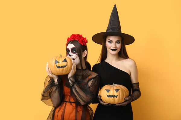 Mladé Ženy Oblečené Halloween Dýněmi Žlutém Pozadí — Stock fotografie