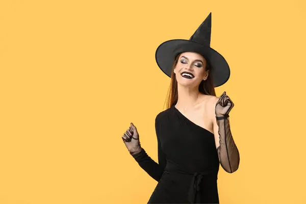 Mladá Žena Oblečená Halloween Jako Čarodějnice Tanec Žlutém Pozadí — Stock fotografie