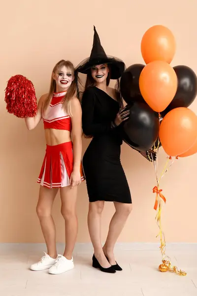 Amigas Vestidas Para Halloween Con Globos Cerca Pared Beige —  Fotos de Stock