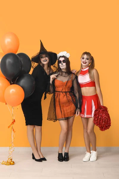 Női Barátok Öltözött Halloween Léggömbök Közelében Sárga Fal — Stock Fotó