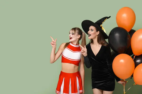 Amici Femminili Vestiti Halloween Con Palloncini Che Puntano Qualcosa Sfondo — Foto Stock