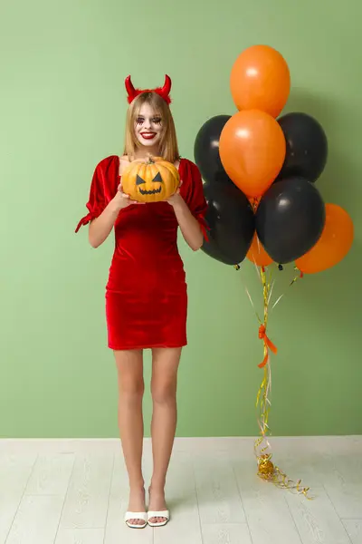Fiatal Öltözött Halloween Ördög Tök Léggömbök Közelében Zöld Fal — Stock Fotó