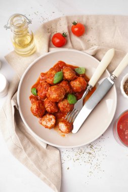 Domates soslu lezzetli köfte tabağı ve beyaz arka planda fesleğen.