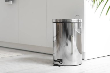 Modern mutfağın içindeki metal çöp tenekesi.