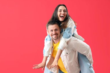 Kırmızı arka planda mutlu genç çift