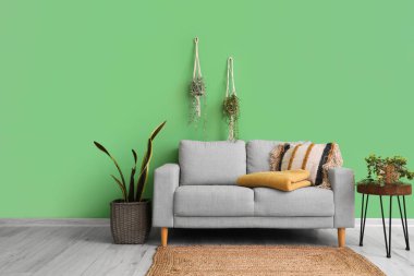 Kanepe ve çiçeklerin üzerinde katlanmış ekoseli oturma odasının içinde.