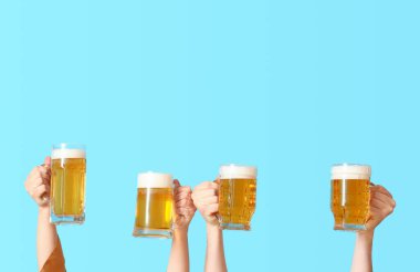 Mavi arka planda soğuk bira kupaları olan kadın ve adam.