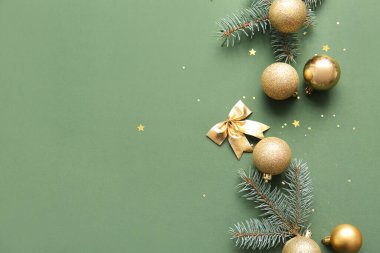 Topları olan Noel ağacı dalları ve yeşil arka planda eğilme