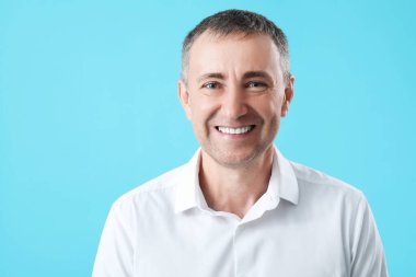 Mavi arka planda mutlu olgun bir adamın portresi