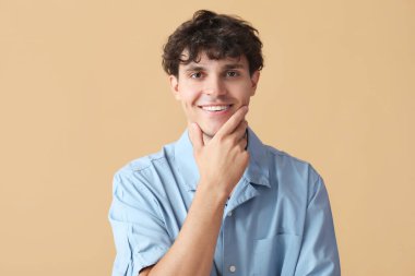 Bej arka planda düşünen genç adamın portresi