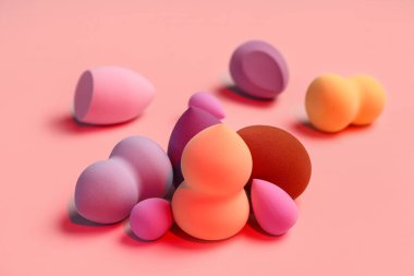 Pembe arka planda farklı makyaj süngerleri