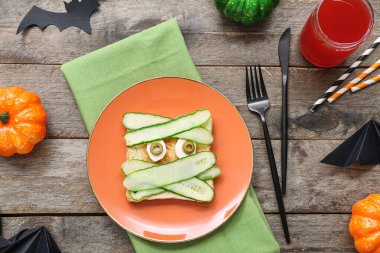 Lezzetli Cadılar Bayramı kahvaltısı ve ahşap arka planda süslemeleri olan kompozisyon