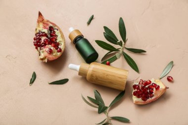 Renkli arka planda gerekli yağ, nar ve bitki dallarından oluşan şişelerle bileşim