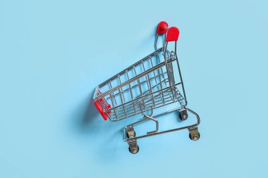 Mavi arka planda alışveriş arabası