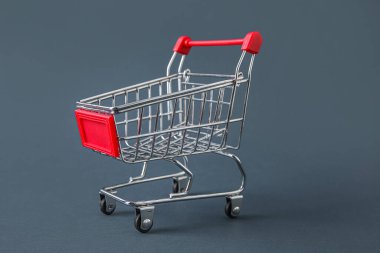 Gri arka planda alışveriş arabası, yakın plan.