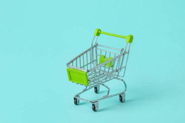 Turkuaz arka planda alışveriş arabası