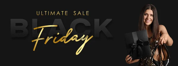 Young woman with shoes and gift box on dark background. Banner for Black Friday Sale