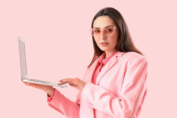 Молодая Женщина Стильном Костюме Ноутбуком Розовом Фоне — стоковое фото