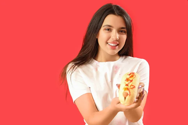 Ładna Młoda Kobieta Smacznym Hot Dogiem Czerwonym Tle — Zdjęcie stockowe