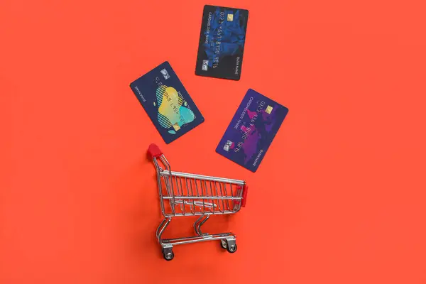 Warenkorb Und Kreditkarten Auf Rotem Hintergrund — Stockfoto