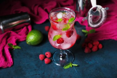 Mavi masada bir bardak taze ahududu mojito.