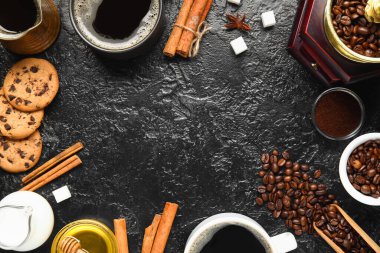 Lezzetli kahve, tarçın, fasulye, kurabiye, şeker ve sütlü fincanlardan yapılmış çerçeve siyah arka planda