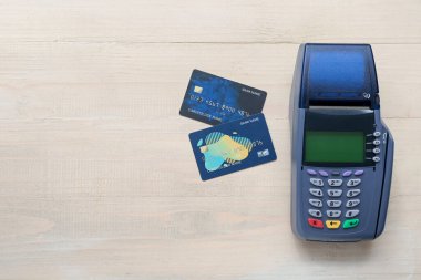 Hafif ahşap zemin üzerinde kredi kartları olan ödeme terminali