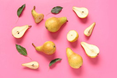 Pembe arka planda olgun armutlar ve yapraklar