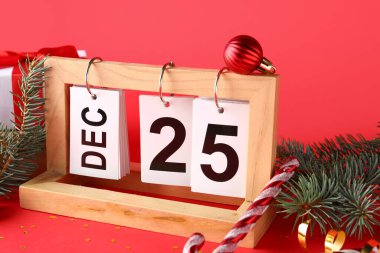 Kırmızı arka planda Noel tarihi olan dekorasyon ve takvimler