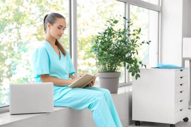 Üniversitede kitap okuyan bir tıp öğrencisi.