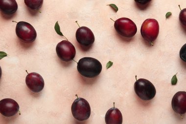 Pembe arka planda taze erik ve yapraklar