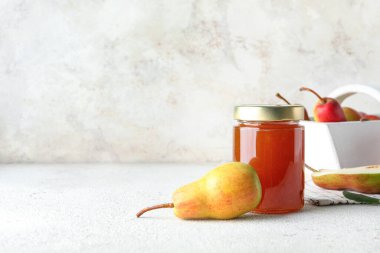 Cam kavanoz armut reçeli beyaz masada.