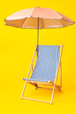 Sarı arka planda şemsiye.