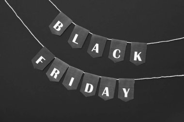 Koyu arkaplanda Kara Cuma yazılı halat ve bayraklar