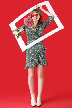 Kırmızı arkaplanda çiçekli ve çerçeveli genç bir kadın