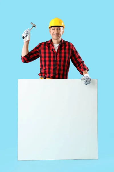 Reifer Arbeiter Mit Hammer Und Leerem Plakat Auf Blauem Hintergrund — Stockfoto