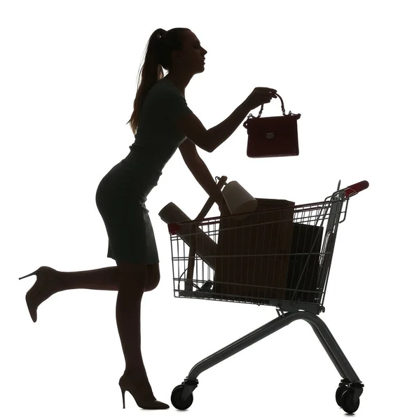 白い背景にバッグとショッピングカートを持つ若い女性のシルエット — ストック写真