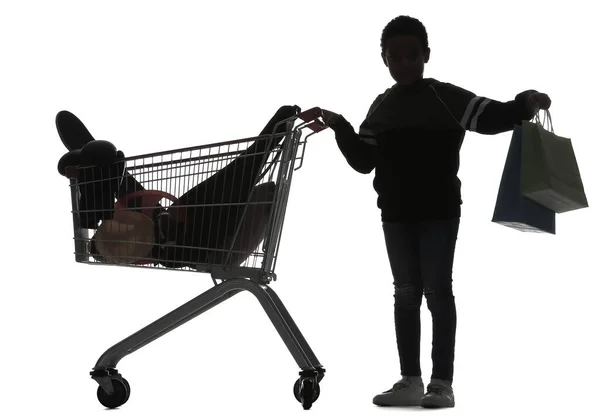 Silhouette Eines Kleinen Jungen Mit Taschen Und Vollem Einkaufswagen Auf — Stockfoto