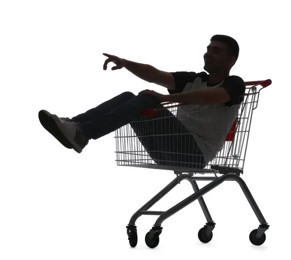 Genç Adamın Silueti Beyaz Arka Plandaki Alışveriş Arabasındaki Bir Şeyi — Stok fotoğraf
