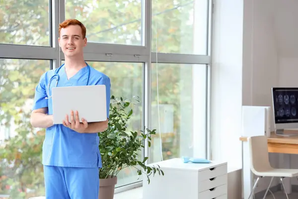 Male medical student with laptop at university