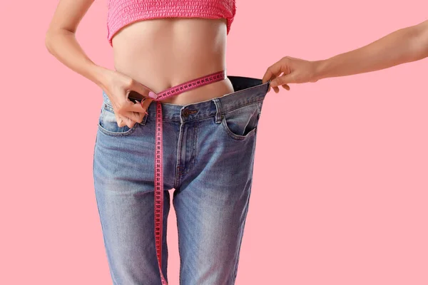 Young Woman Loose Jeans Measuring Her Waist Pink Background Weight — Stock Photo, Image